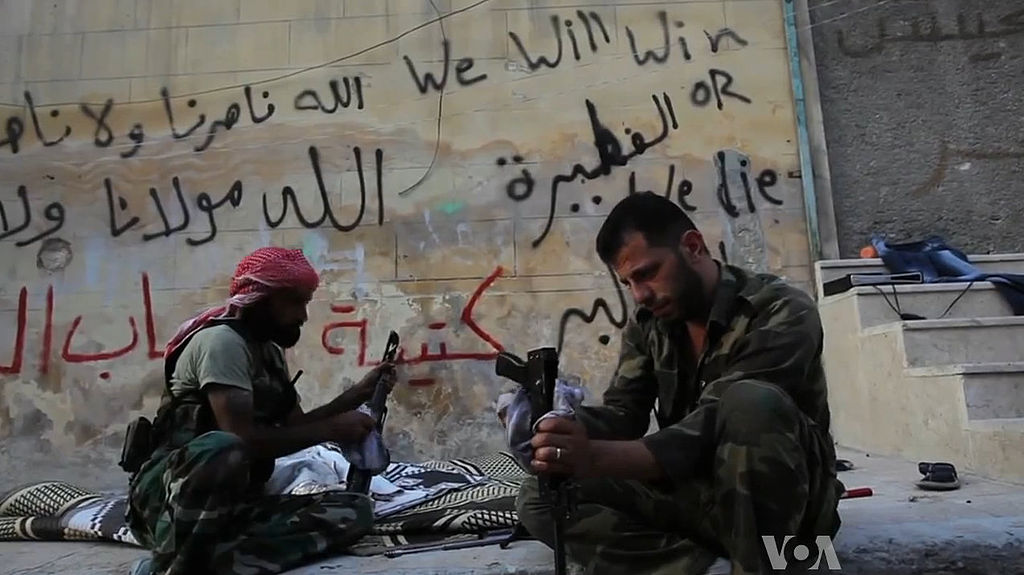 Image by Scott Bobb via Wikimedia Commons. https://commons.wikimedia.org/wiki/File:FSA_rebels_cleaning_their_AK47s.jpg