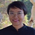 Headshot of Dr Abidah Setyowati. Abidah is gently smiling, wearing glasses, dark shirt and has dar short hair.